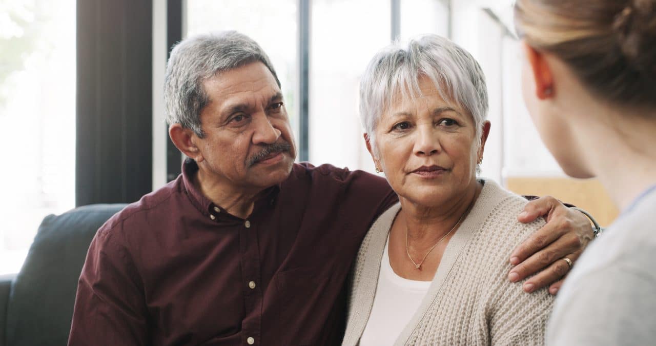 Couple supporting each other at hearing appointment.