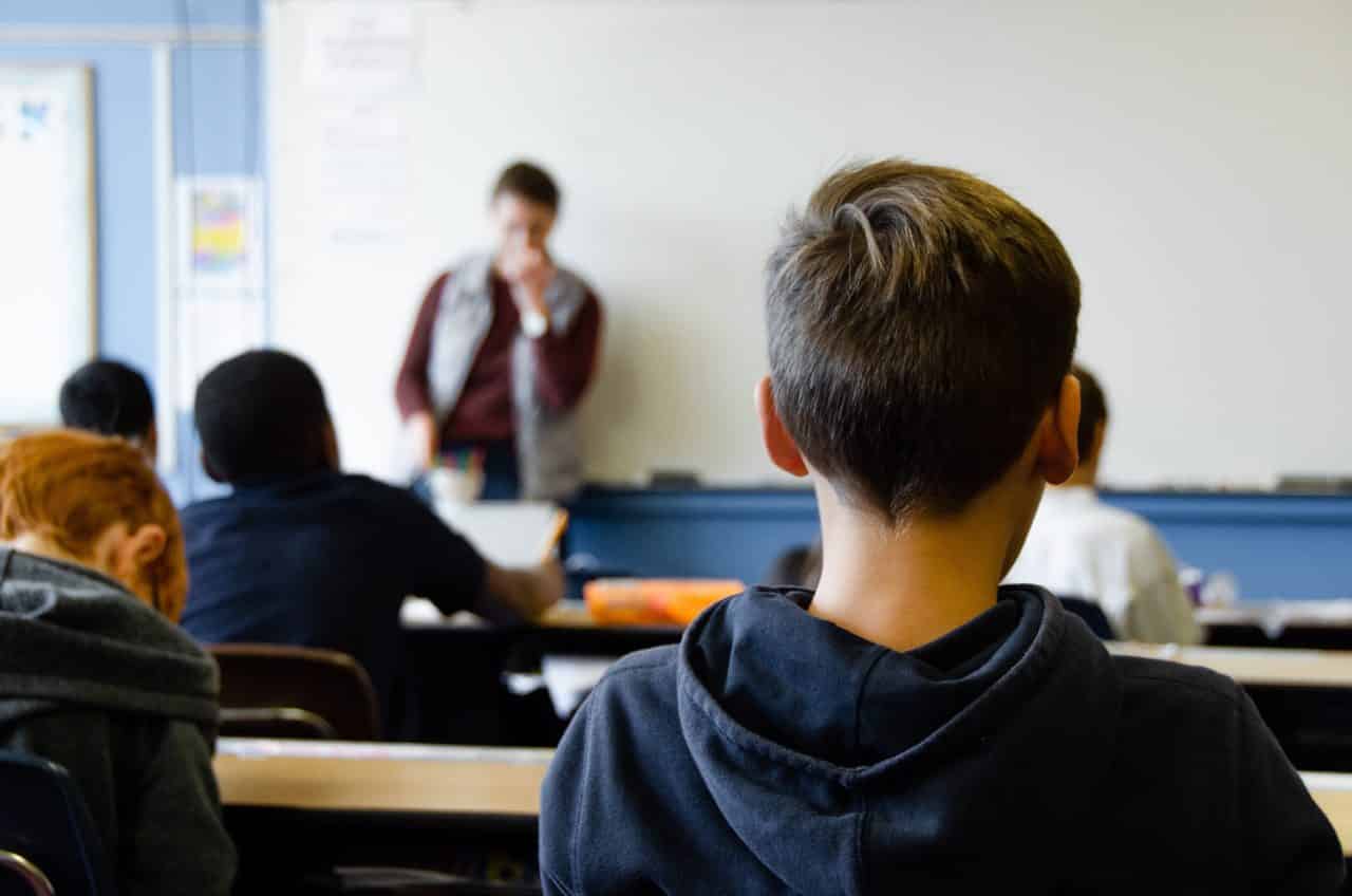 Children listening to a teacher in a classroom environment.