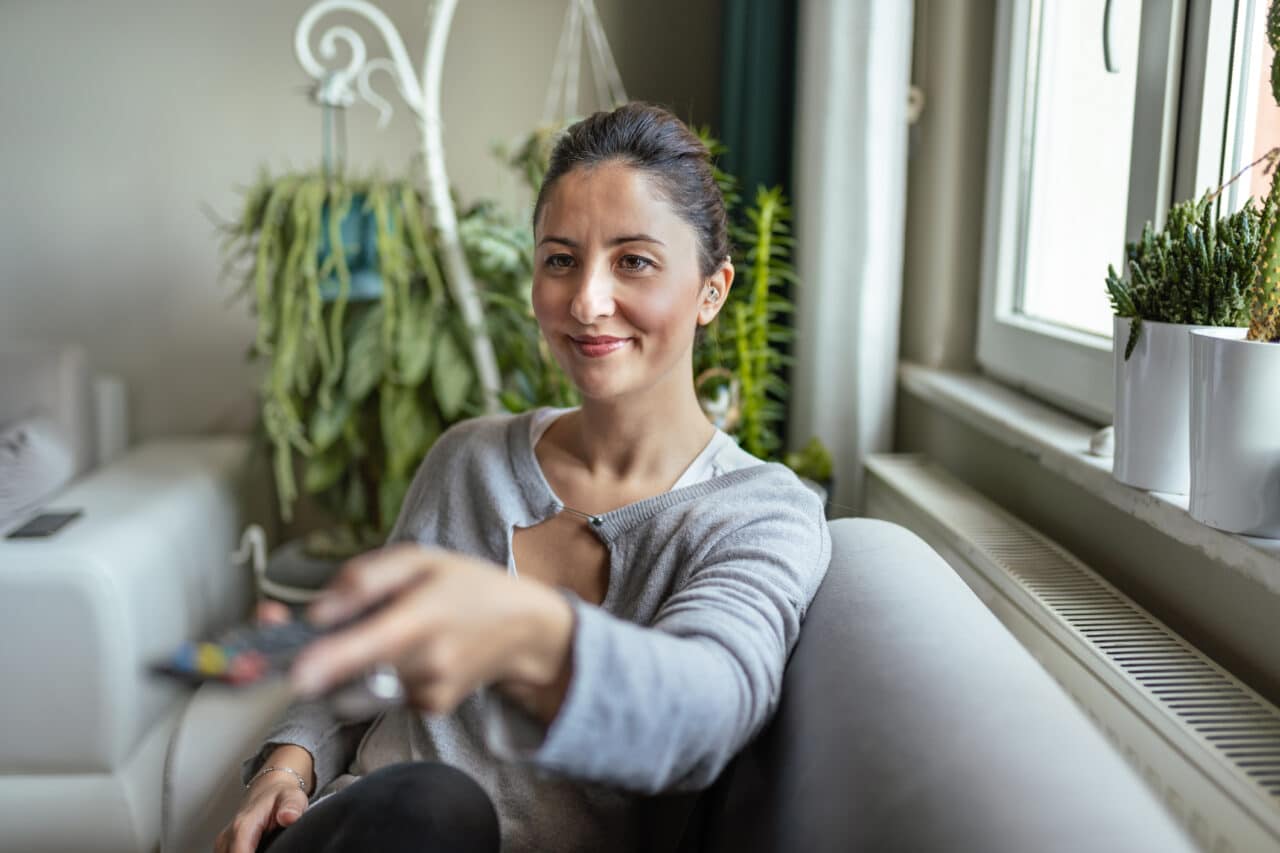 Young Adult Woman with Hearing Aid watching television