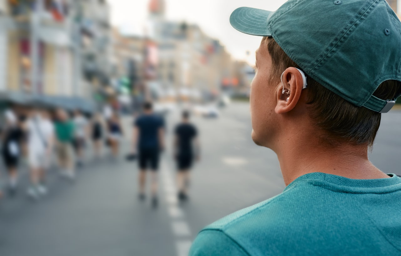 Man with hearing aids stands on street