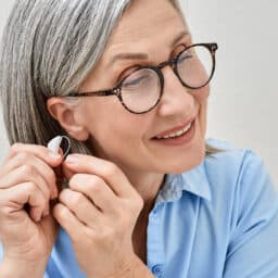 Woman putting on her new hearing aid