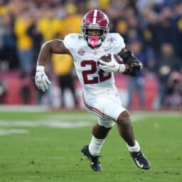 Football player carries the football.